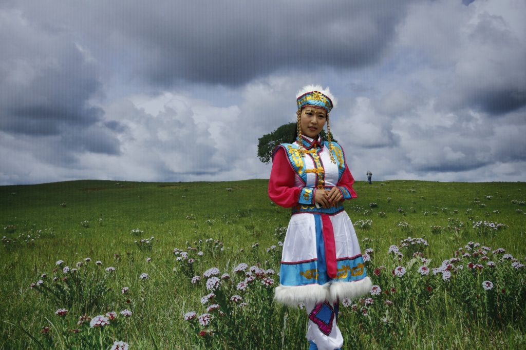 A young Mongolian girl is in the field