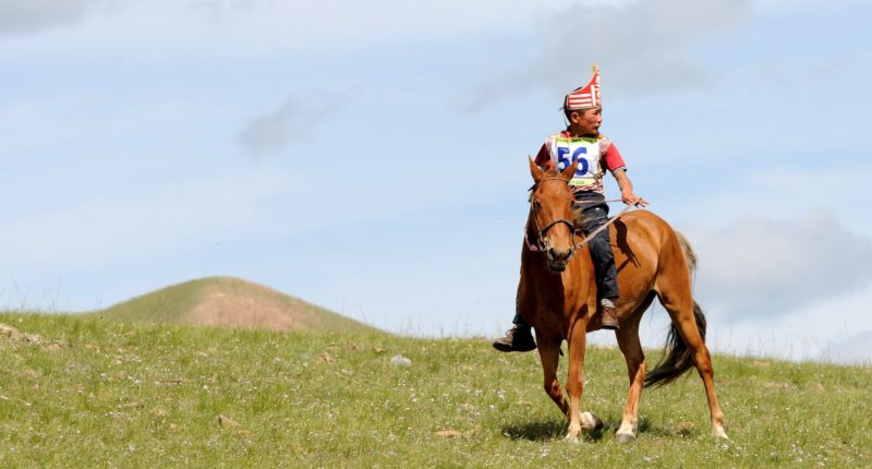 Mongolia a boy riding his horse