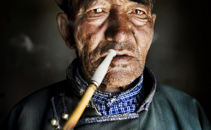 A traditional pipe is smoked by a Mongolian