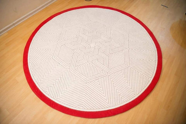 An embroidered round felt rug